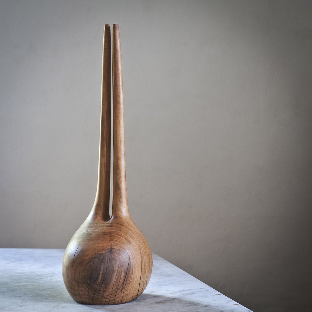 Dettaglio della firma dell'artista Estebanland sulla base della scultura in ciliegio.