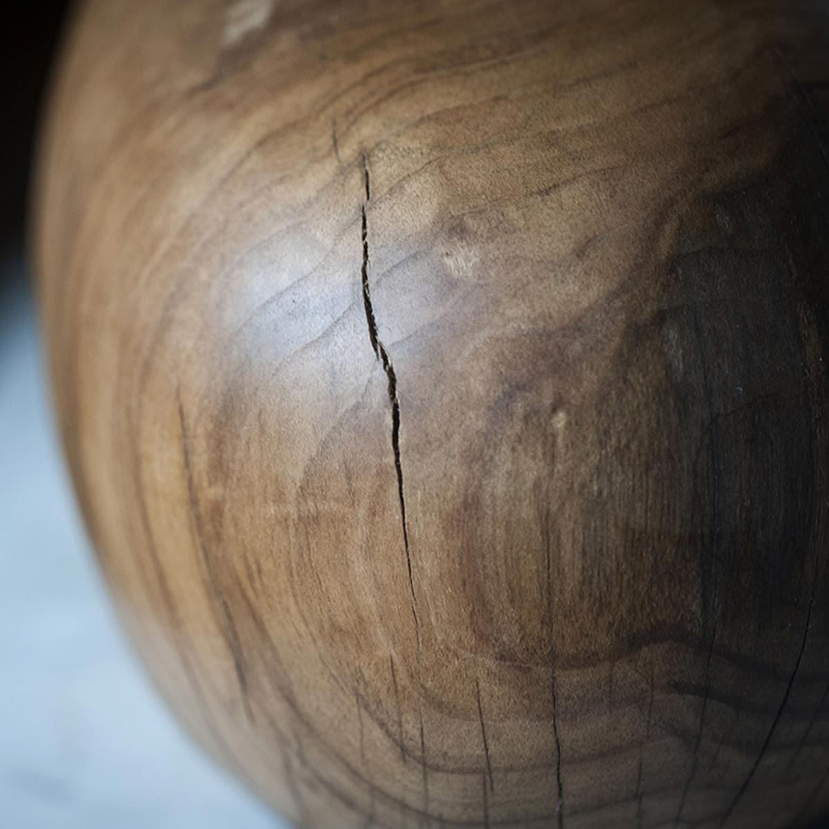 La scultura in legno di ciliegio esposta da sola su una mensola, mostrando la sua forma a fiamma.