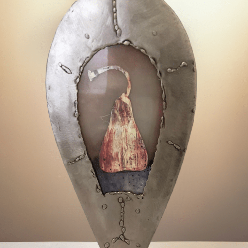 Primo piano della pera racchiusa all'interno della scultura in metallo Cuore Sacro