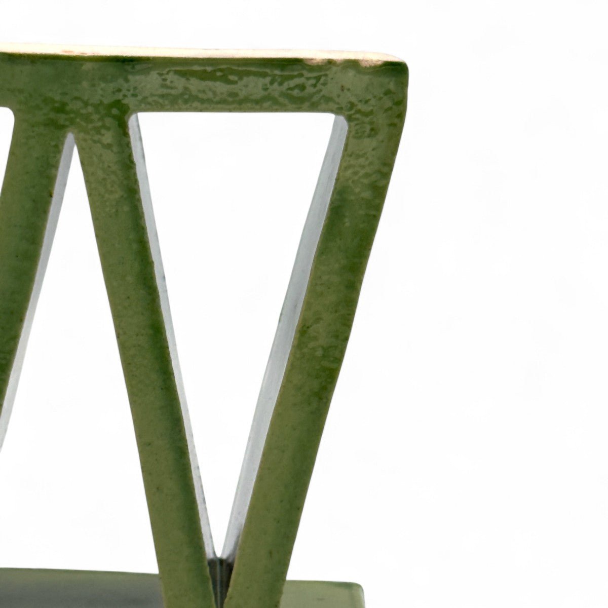 Primo piano dello smalto verde salvia lucido e delle sue sfumature uniche sulla scultura.