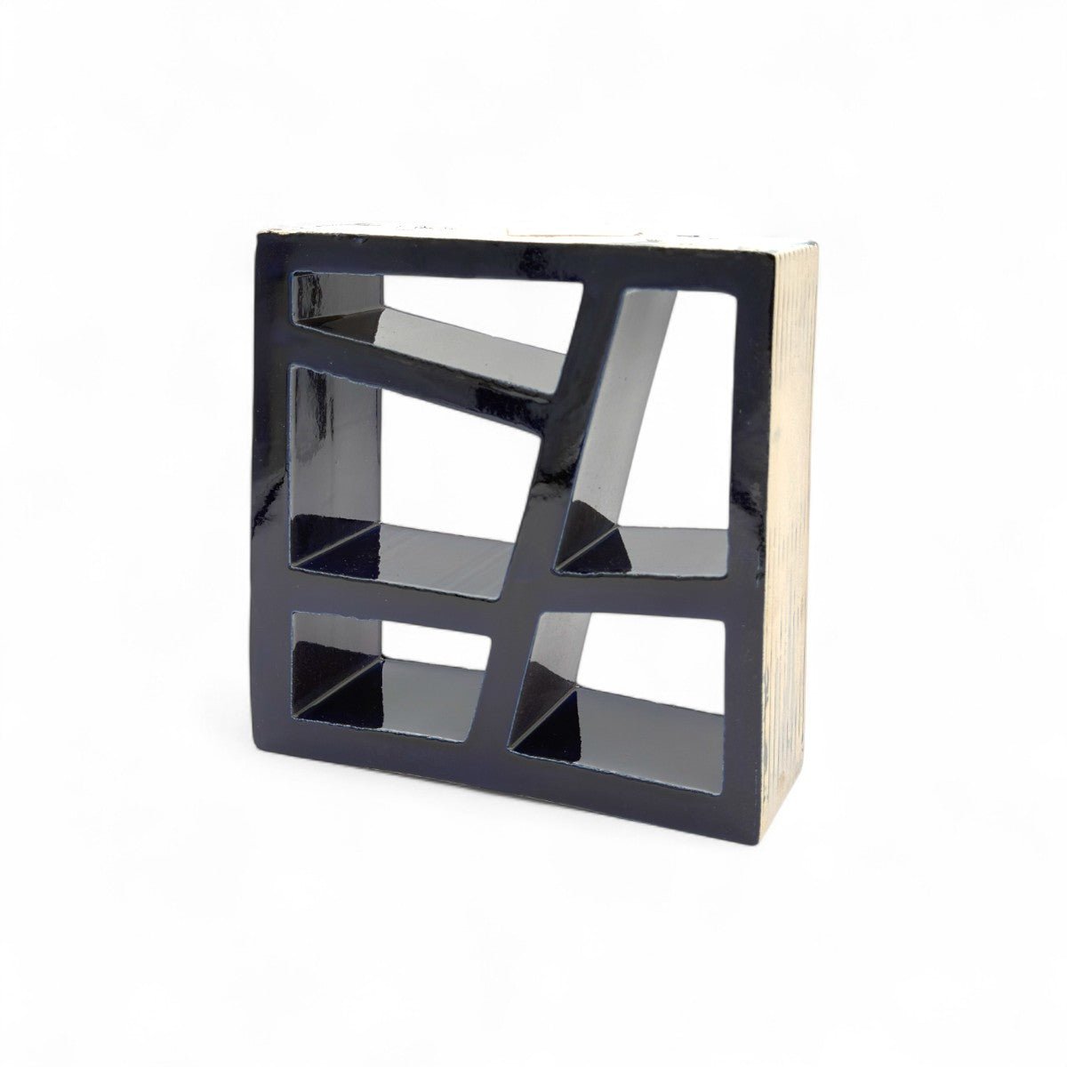 Vista di tre quarti della scultura in terracotta blu, che mostra il gioco di pieni e vuoti.