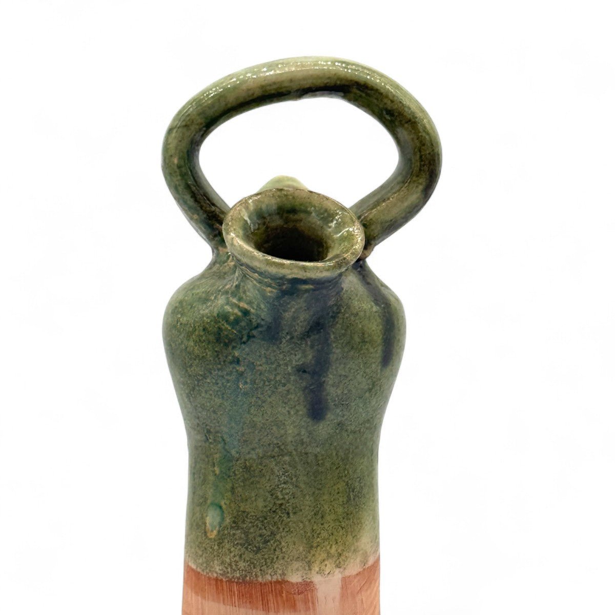 Vista di tre quarti della scultura in terracotta verde, che evidenzia il contrasto dei materiali.