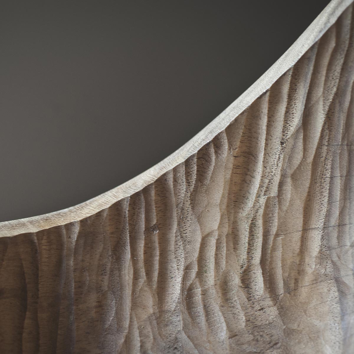 Dettaglio della firma dell'artista Estebanland incisa sulla base della scultura in legno.