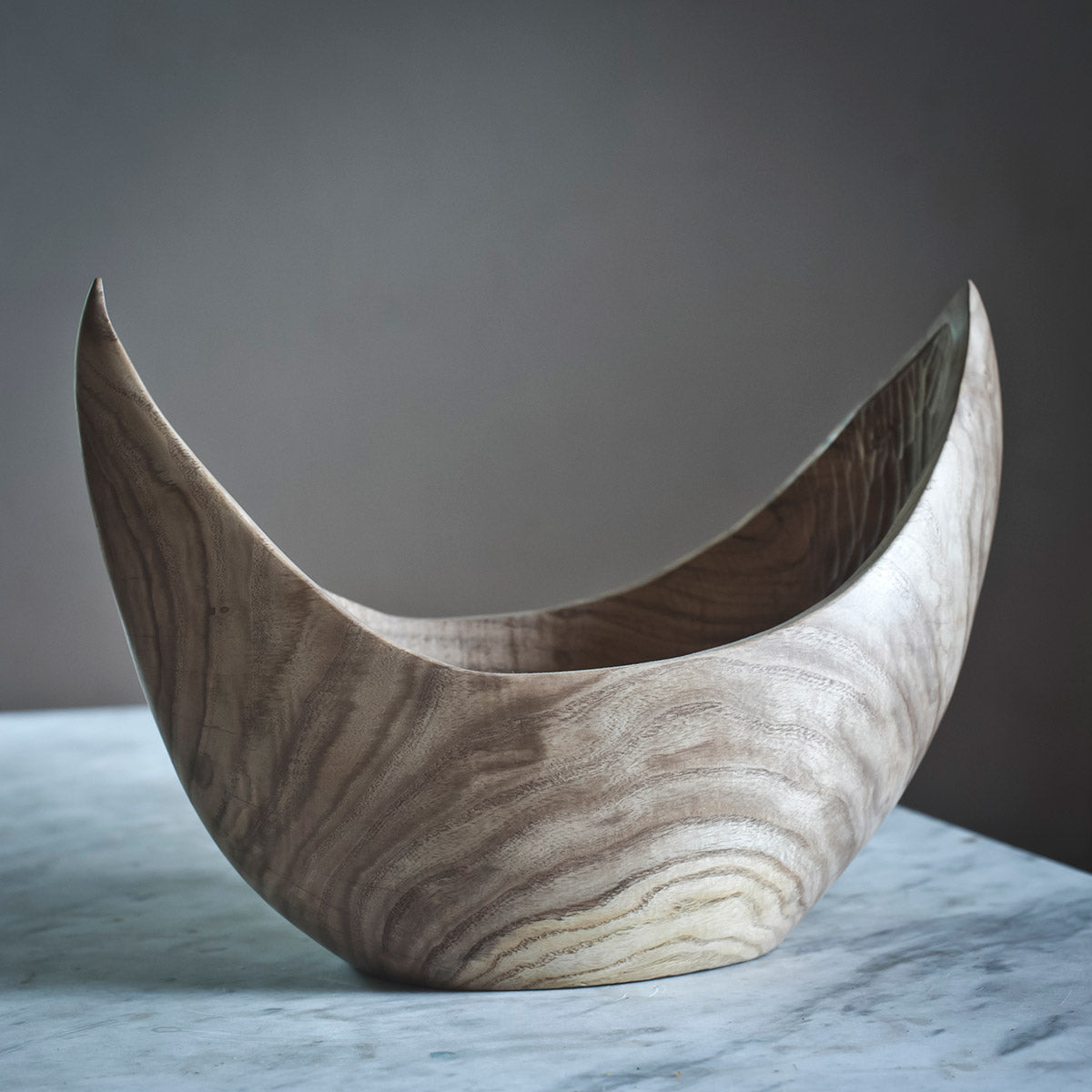 La scultura in legno di olmo usata come centrotavola su un tavolo da pranzo di design.