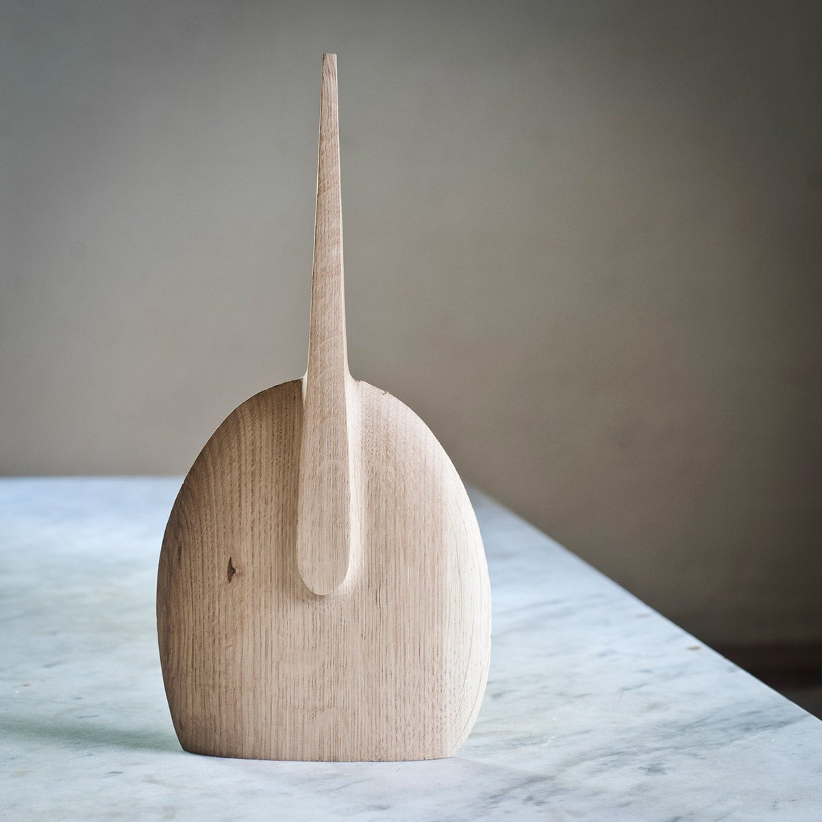 Primo piano della superficie levigata e della venatura del legno di rovere della scultura.