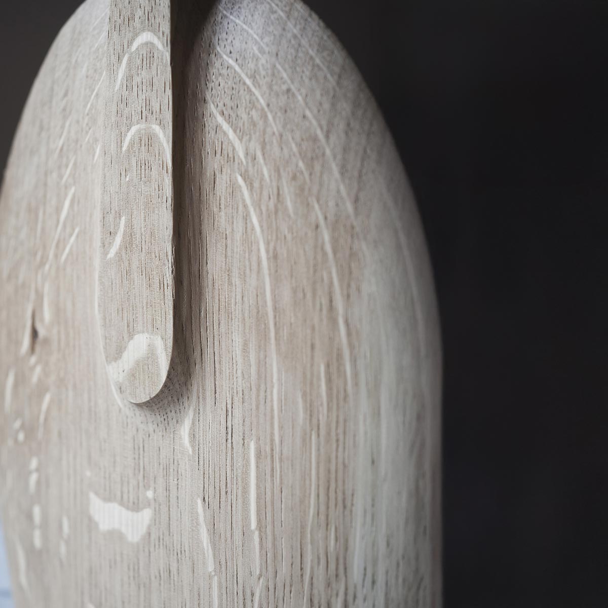 Dettaglio della firma dell'artista Estebanland sulla base curva della scultura in rovere.