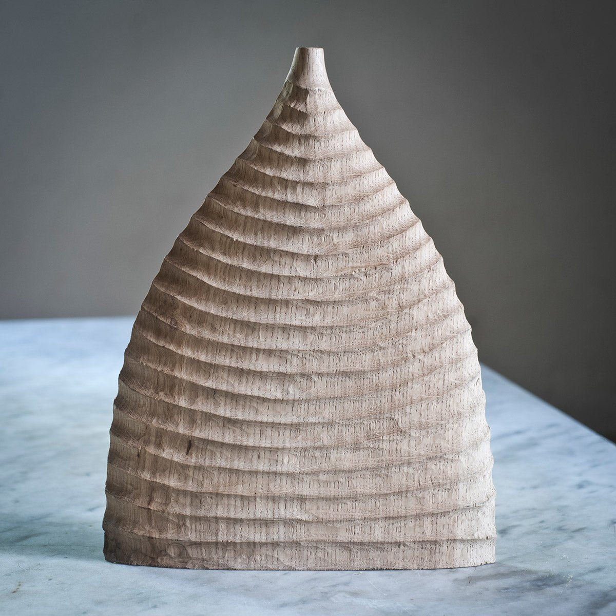 Dettaglio della firma dell'artista Estebanland incisa sulla base della scultura in rovere.