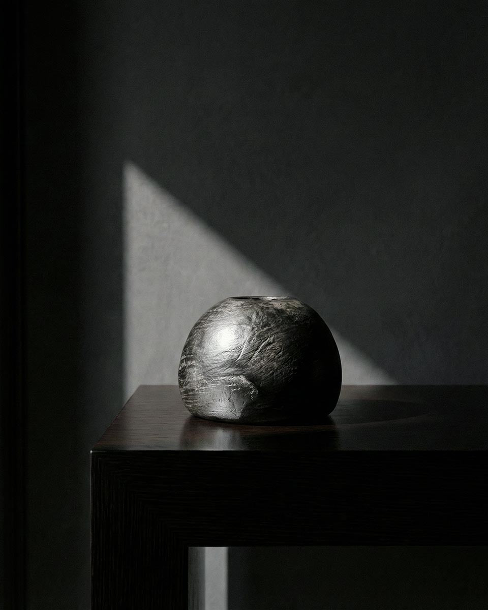 Scultura artistica sfera ceramica nera Najed con illuminazione drammatica