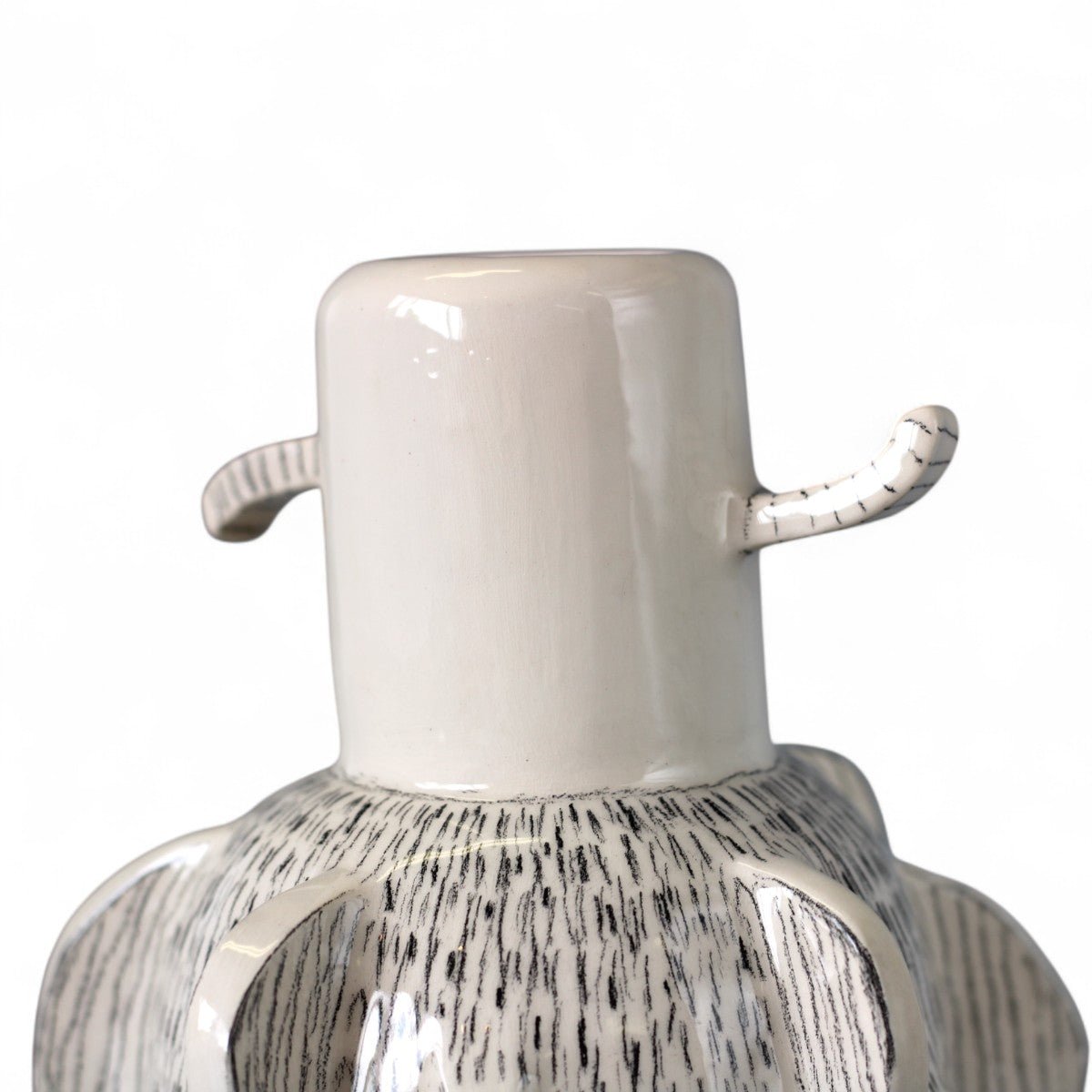 Il vaso scultoreo in ceramica esposto su una mensola di legno, esaltandone lo stile naturale.