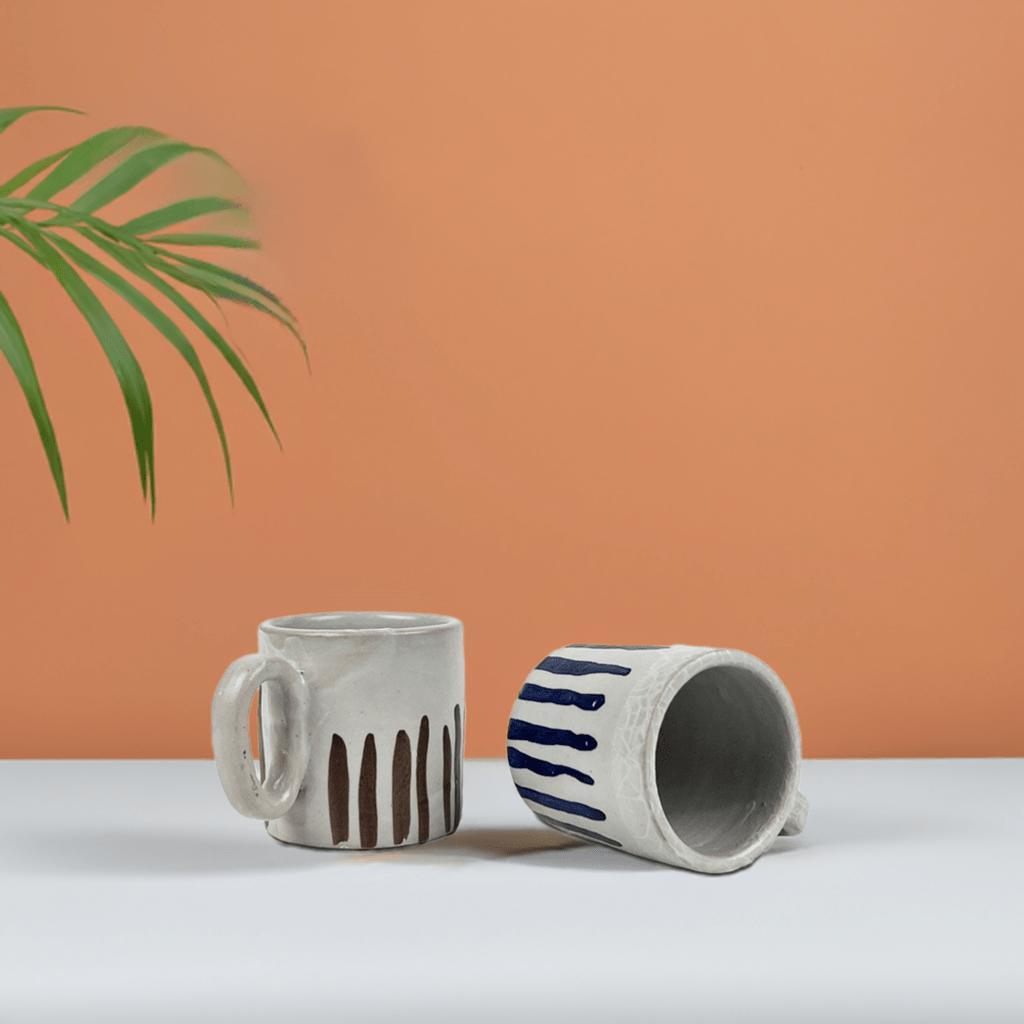 Le due tazze del set "coppia di tazze blu e cacao" esposte su una mensola in cucina.