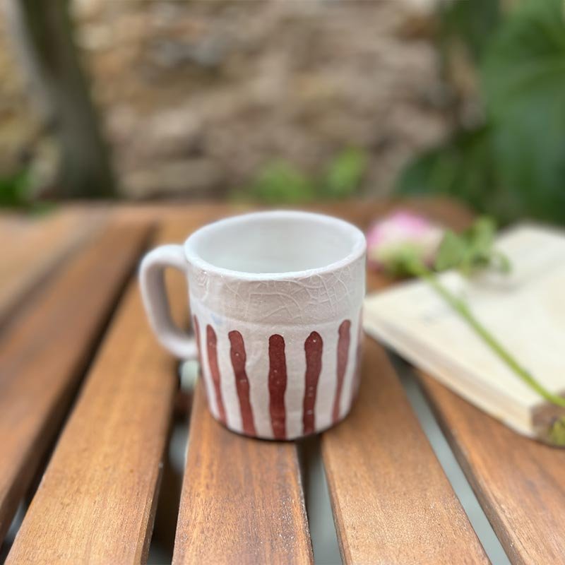 Mani che tengono una tazza della Coppia Blu e rubino, mostrando il manico ergonomico.