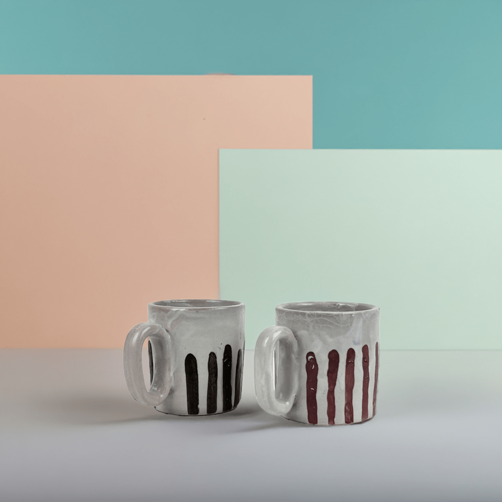 Dettaglio della pennellata blu profondo sulla ceramica bianco sporco della tazza.