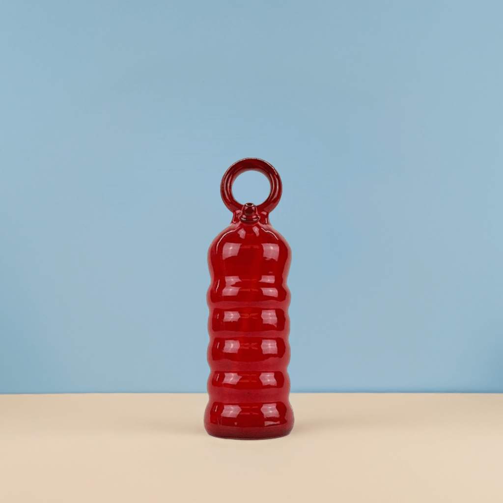 Il Botijo Rojo come punto di colore su una mensola bianca in un interno minimalista.