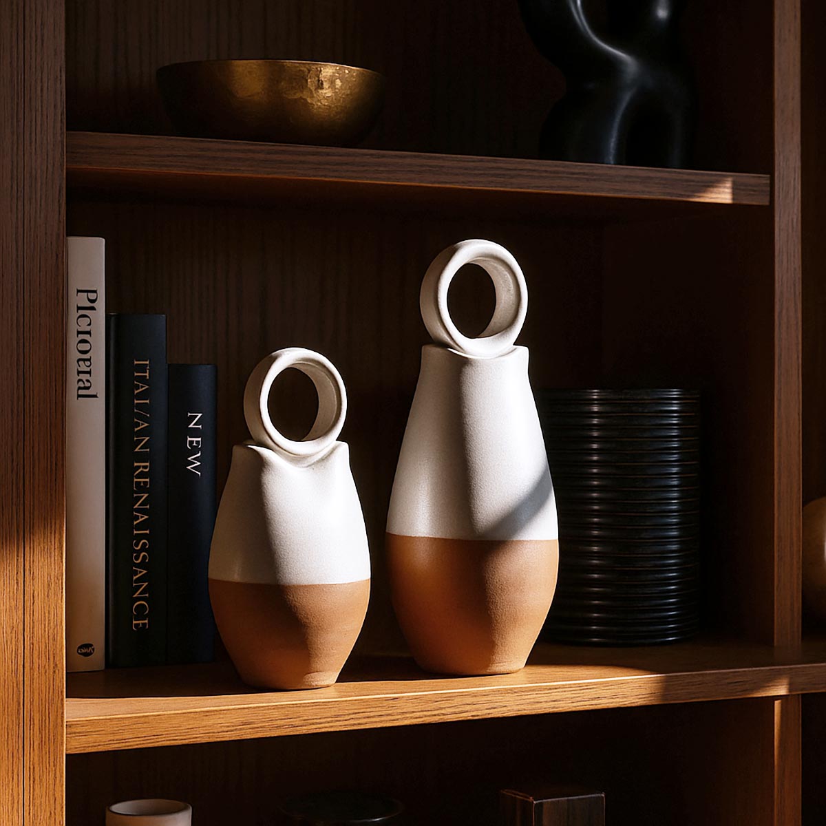 Primo piano del contrasto materico tra la ceramica bianca liscia e la terracotta grezza dei vasi.