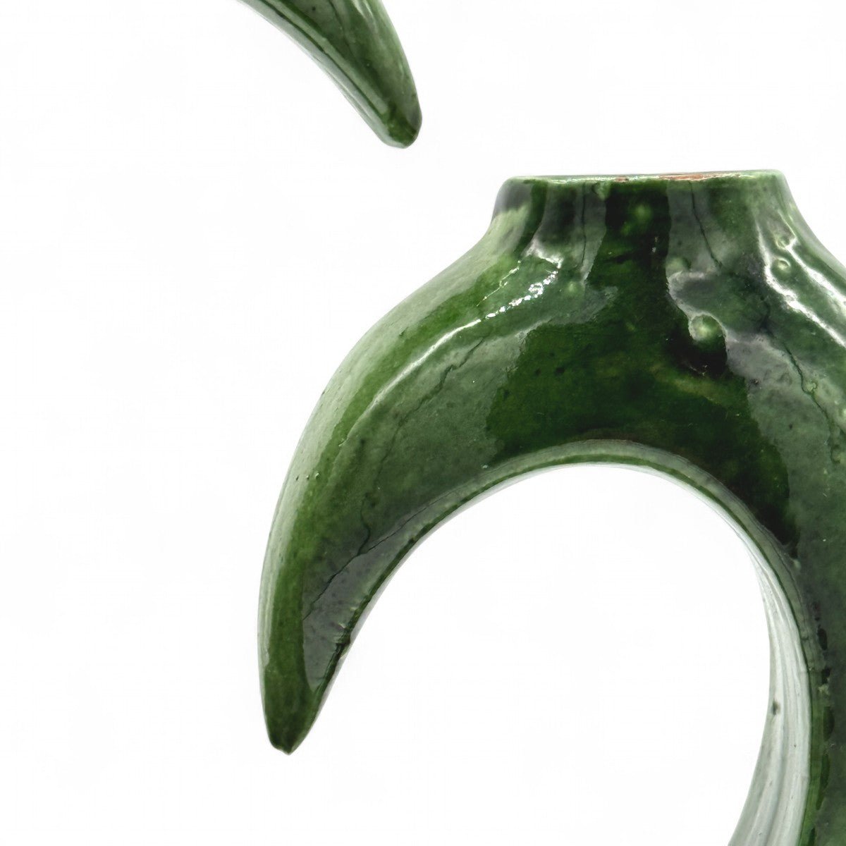 Mano che sfiora la superficie liscia e smaltata del vaso berbero, mostrandone la finitura.