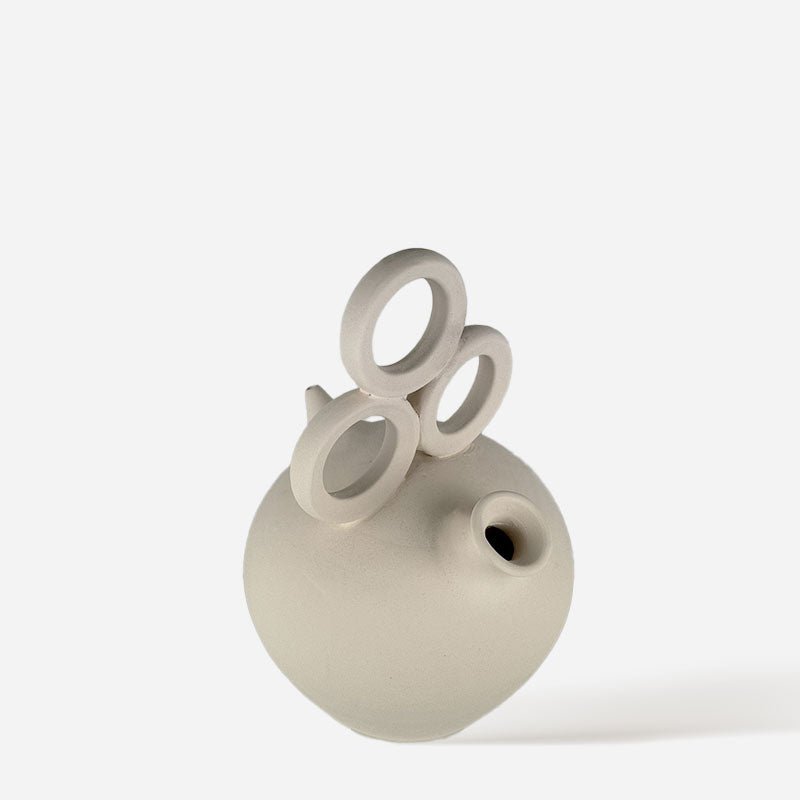 Mano che posiziona il Vaso Luz de Fiesta su un tavolo apparecchiato per una festa all'aperto.