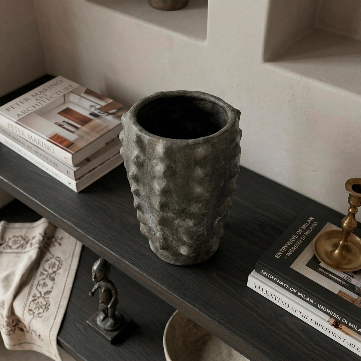 Dettaglio delle borchie a rilievo modellate a mano sulla superficie antracite del vaso.