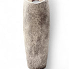 La scultura in ceramica Anima Ovale (alta 50 cm) accanto a una sedia per mostrare le dimensioni.