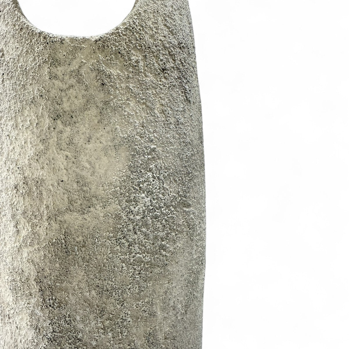 La scultura in ceramica Anima Ovale posata a terra in un interno minimalista.