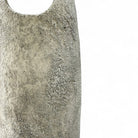 La scultura in ceramica Anima Ovale posata a terra in un interno minimalista.