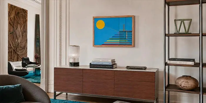 quadro attaccato alla parete in un living di lusso con scultura verde su libreria
