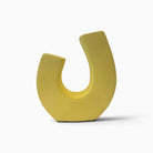Vaso di design Bilico in ceramica giallo burro con forma a U asimmetrica