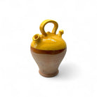 Il botijo vintage spagnolo esposto su una mensola di legno, come scultura domestica.