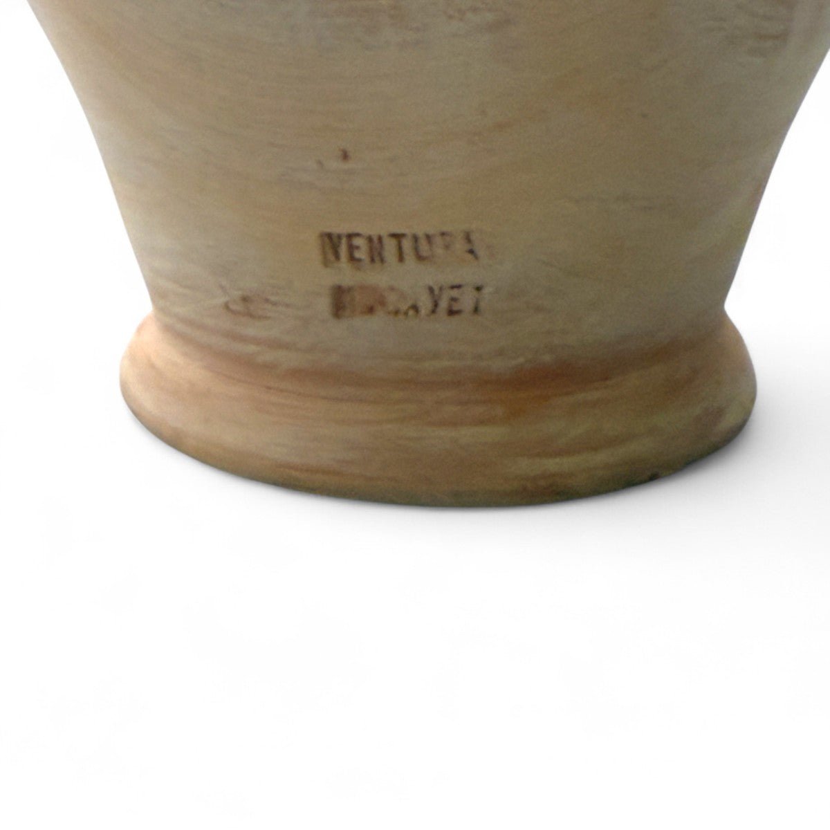 Mano che sfiora la patina del tempo sulla terracotta del botijo vintage spagnolo.