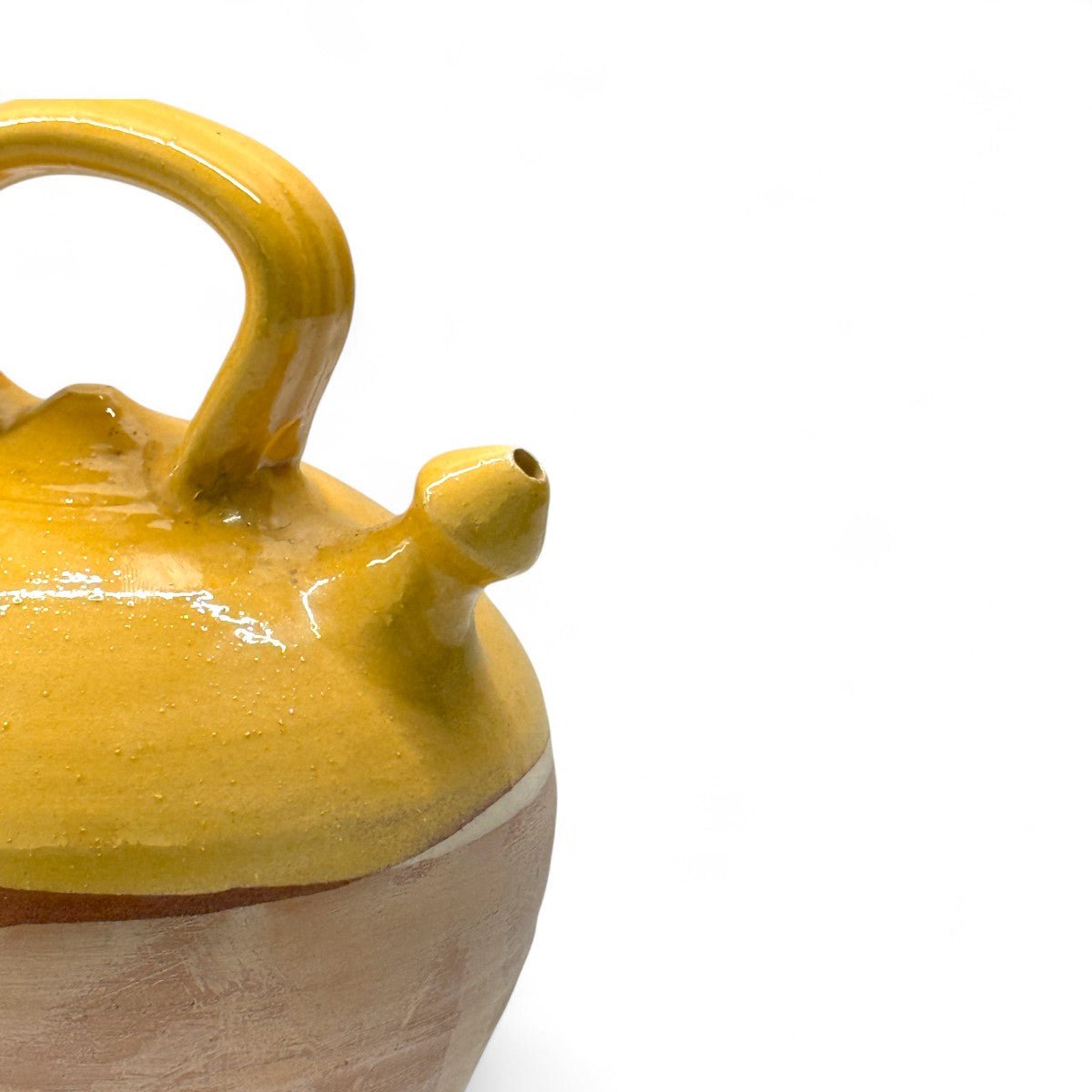 Luce del sole che colpisce lo smalto color miele del botijo, esaltandone il calore.