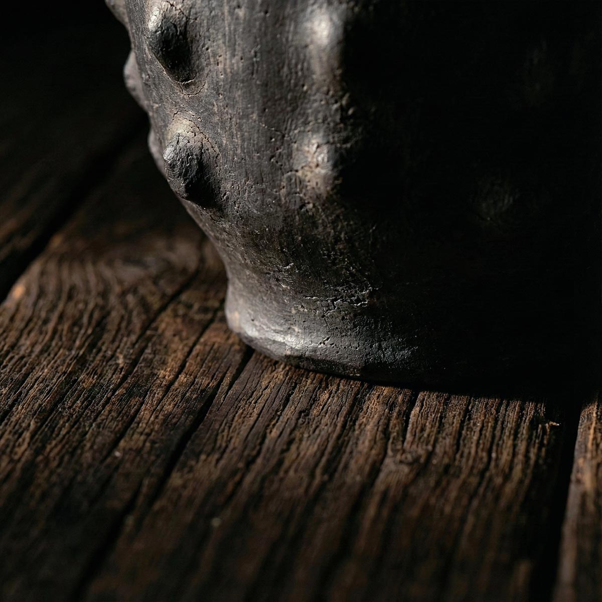 Dettaglio artistico calice nero scolpito Sejnane su superficie materica scura.