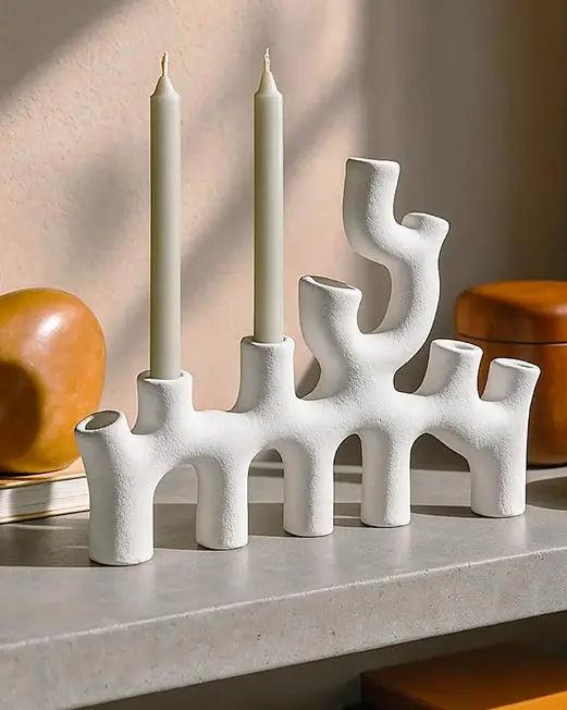 candelabro di design in ceramica bianca sopra una mensola in un interno moderno