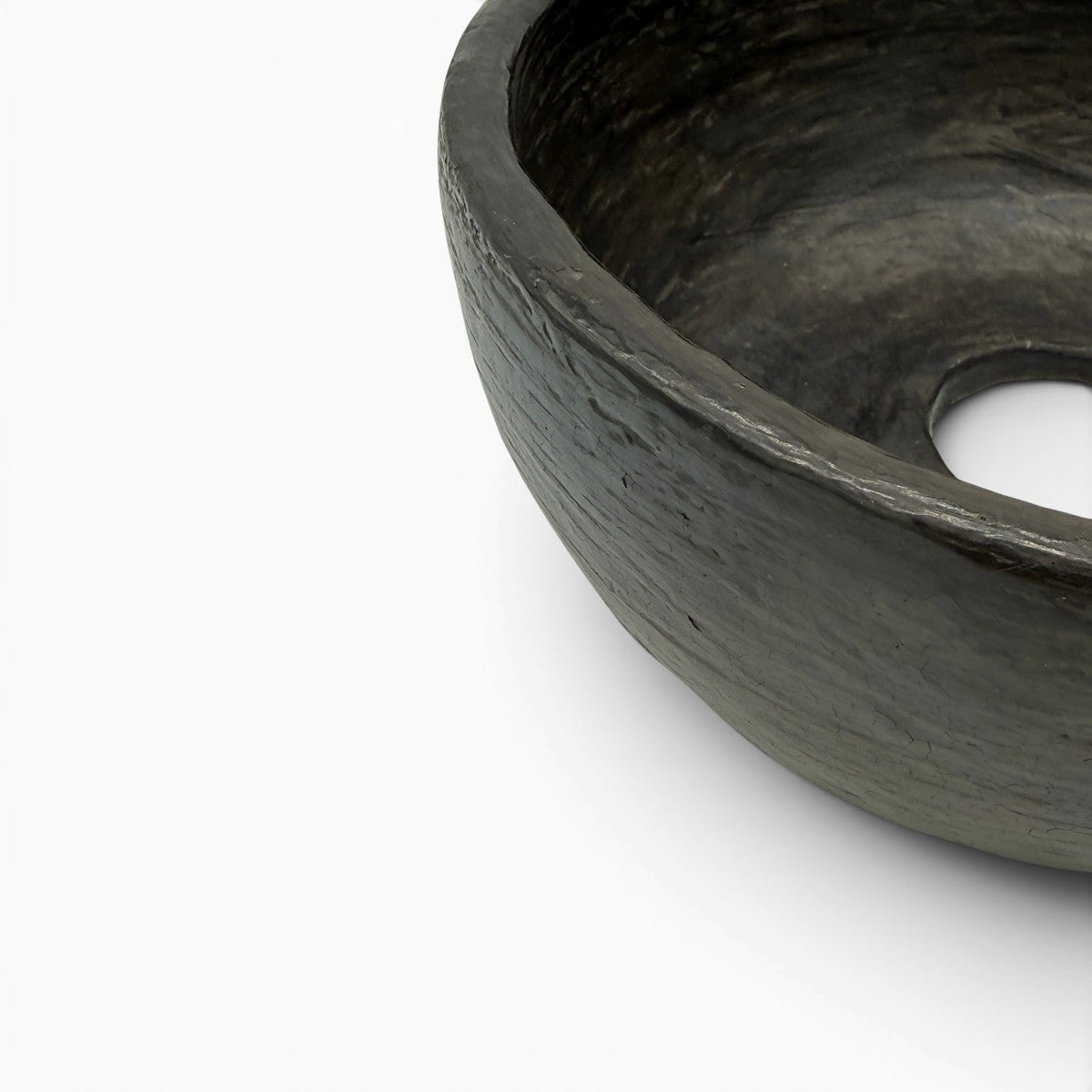 La ciotola Cratere del Vuoto esposta come magnetico accento di design su un tavolo minimalista.