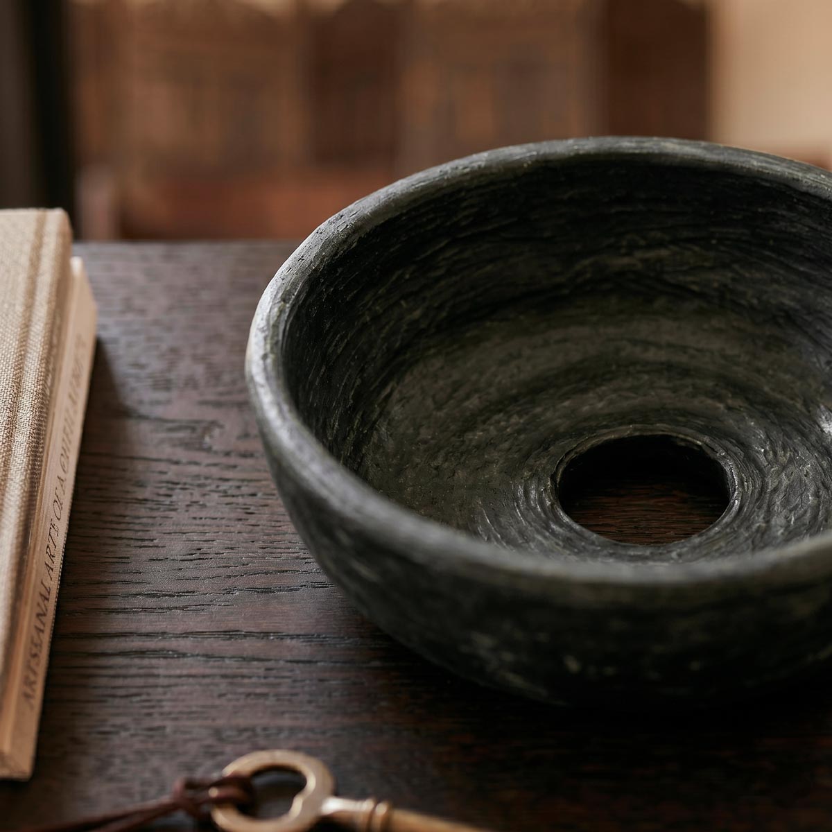 Segni concentrici di levigatura a conchiglia visibili all'interno del bacile nero metallizzato.