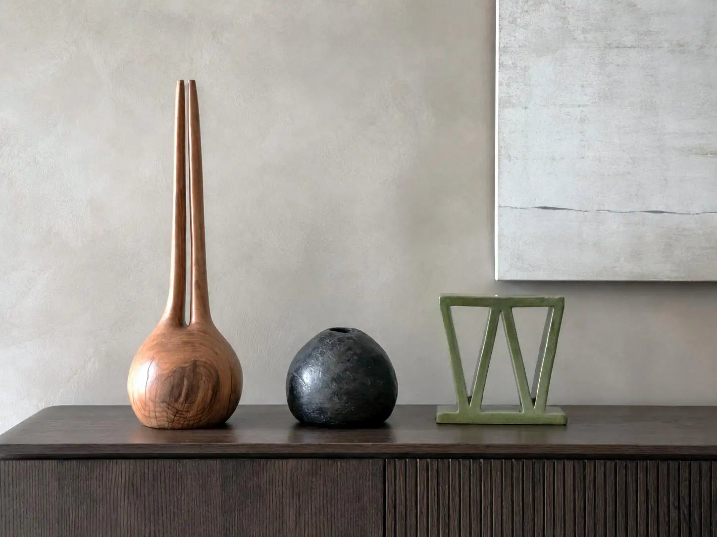 composizione di vasi di design di diverse fome e misure su una madia moderna in legno scuro