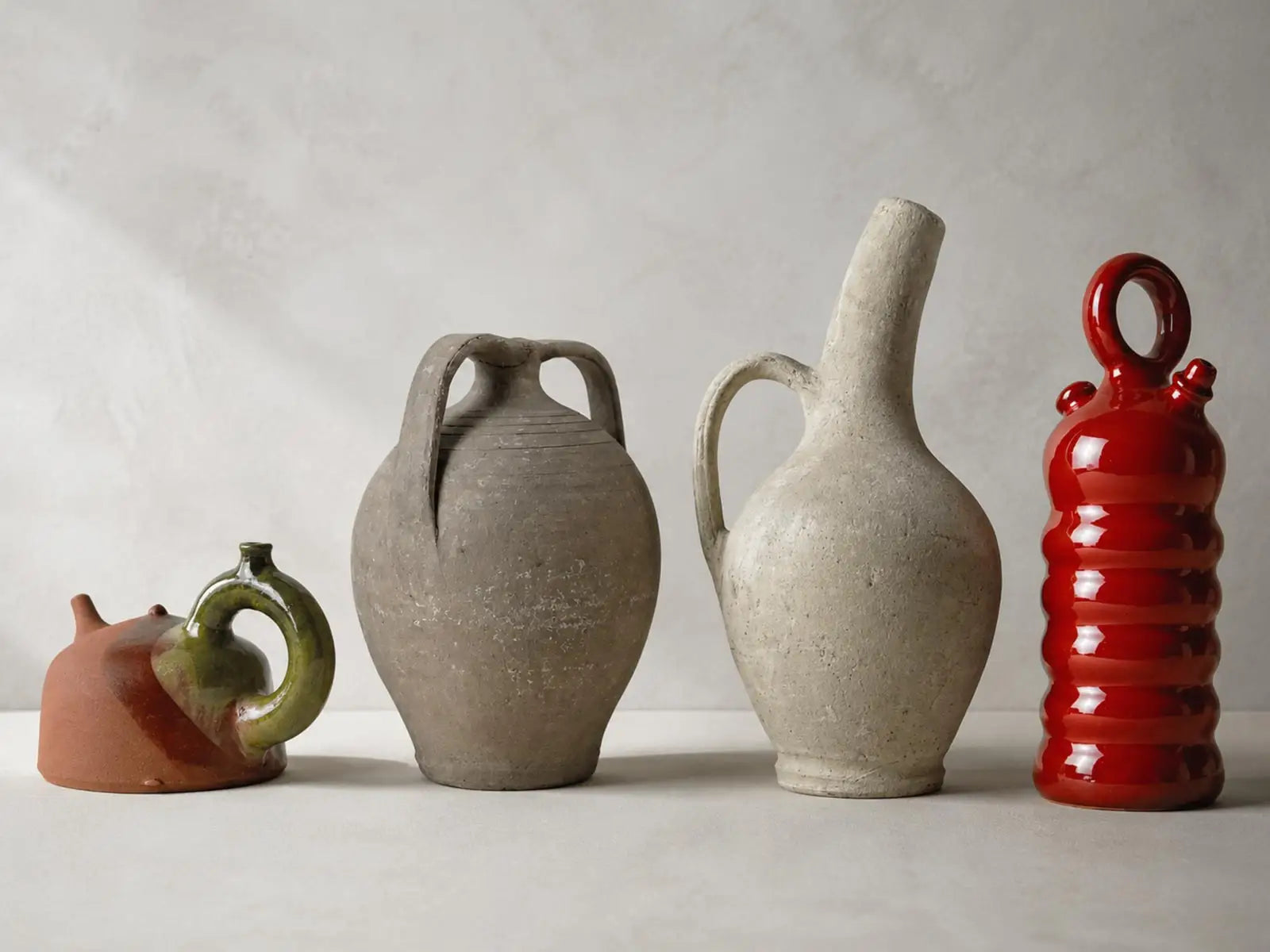 composizione di vasi su ambientazione chiara, diverse tecniche e terracotta, ceramica, gres. diverse texture e diversi materiali
