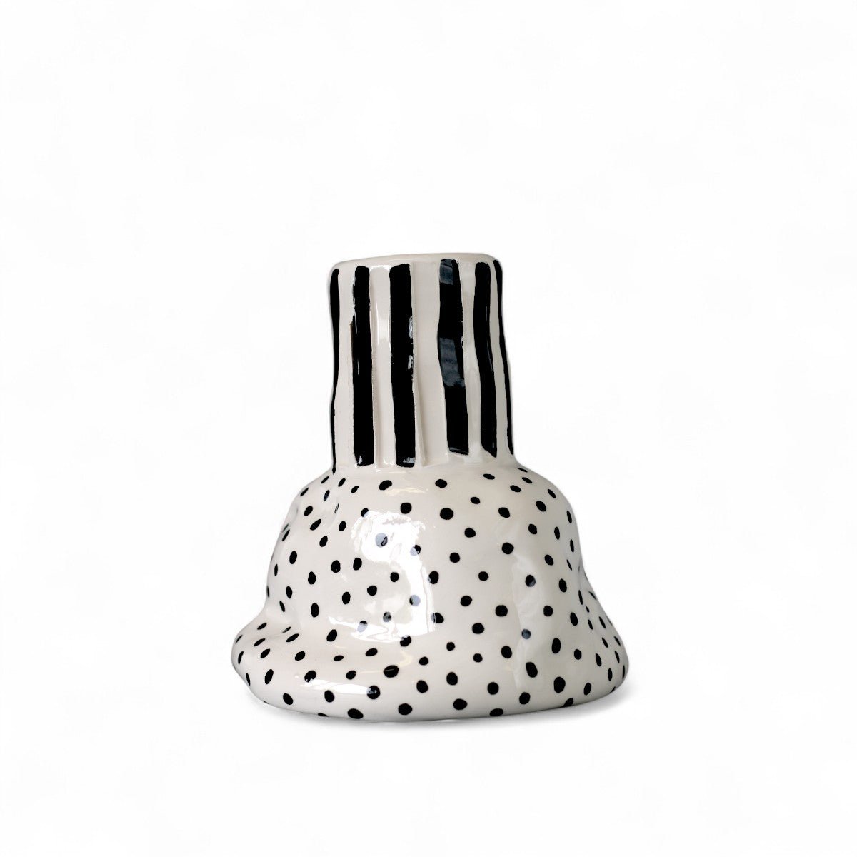 Il vaso in ceramica a righe che accoglie un singolo fiore, esaltandone la forma.