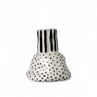 Il vaso in ceramica a righe che accoglie un singolo fiore, esaltandone la forma.