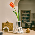 Il vaso in ceramica a righe esposto su una mensola come scultura di design.