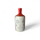 Primo piano del volto stilizzato della donna che "vede" su un vaso della coppia.