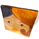 La coppia di mattonelle Idda & Iddu esposte in appoggio su una pila di libri d'arte.