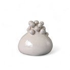 Il piccolo vaso in ceramica artigianale esposto su una mensola scura per esaltarne la forma.