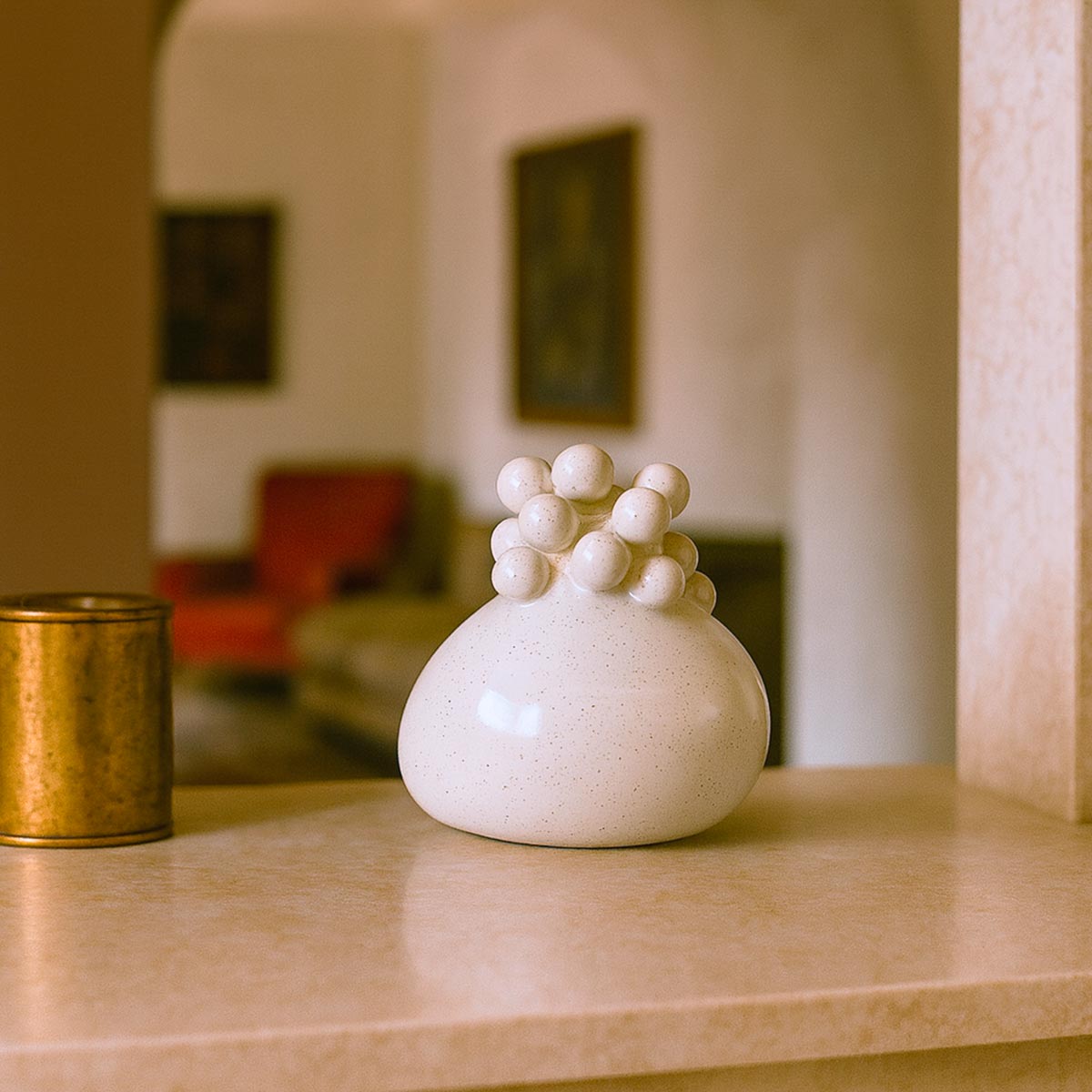 Primo piano delle sfere in rilievo, come un grappolo di stelle, sul vaso in ceramica.