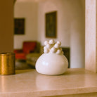 Primo piano delle sfere in rilievo, come un grappolo di stelle, sul vaso in ceramica.