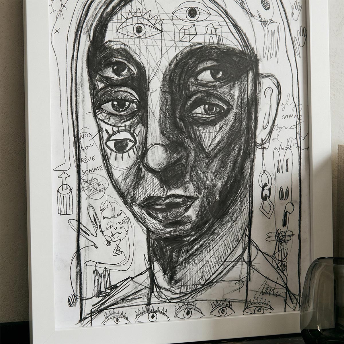 Primo piano dell'ombra densa a carboncino che definisce la matericità del ritratto.