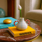 Primo piano del reticolo blu, che richiama un disegno a mano libera, sul vaso in ceramica.