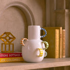 Primo piano delle maniglie multiple, disposte come piccole ali, sul vaso in ceramica.