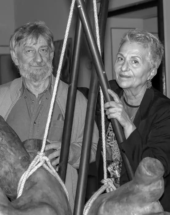 Gabriella Gaudino e Roberto Giuntoli nel loro laboratorio artistico, circondati da busti scultorei in ceramica e manichini.