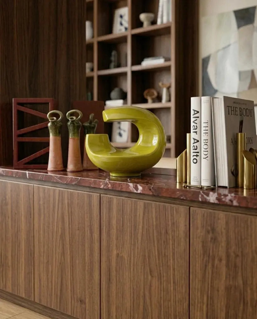 Interno minimalista con madia essenziale vaso materico libro d’arte e piccolo oggetto decorativo