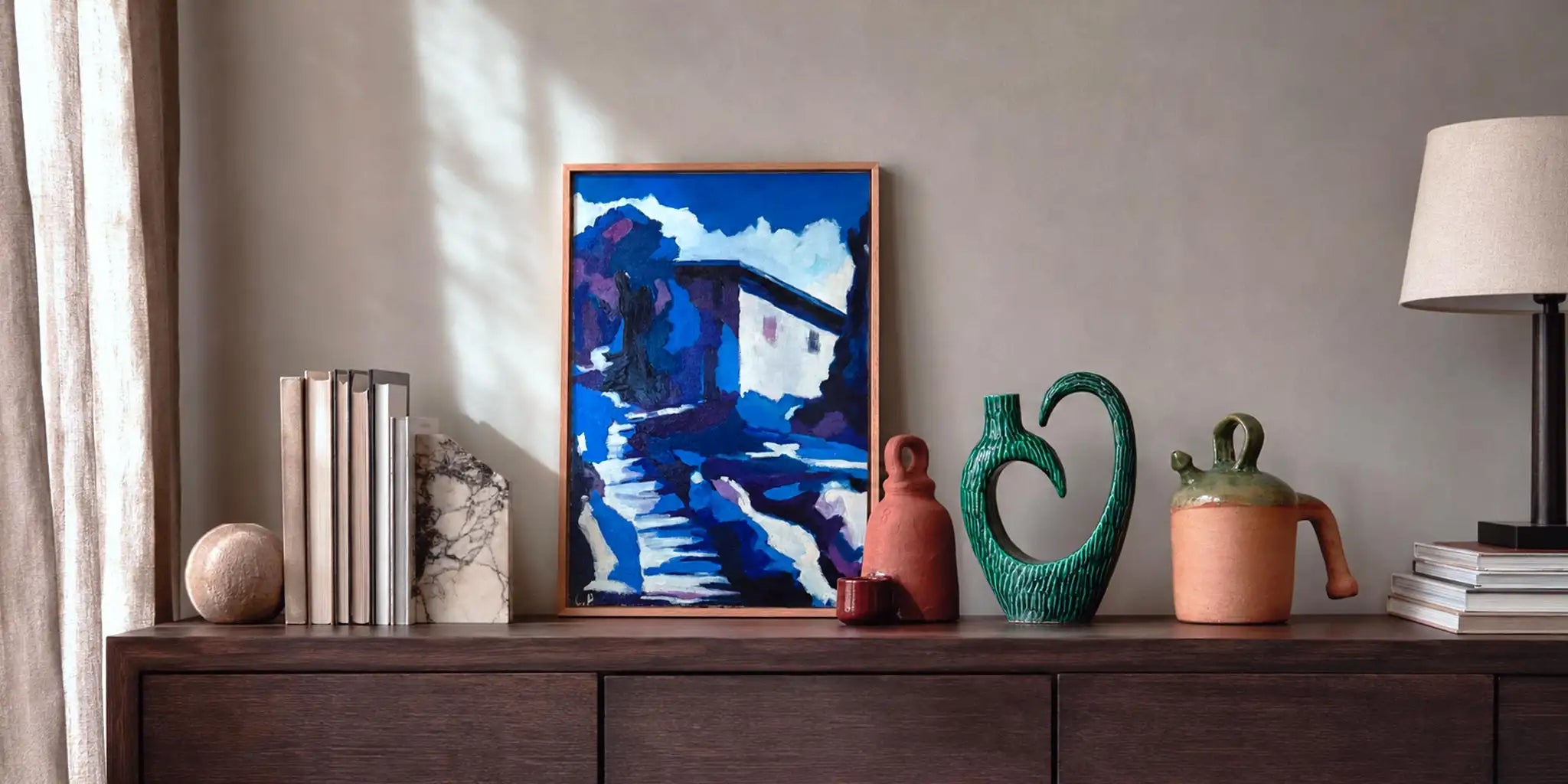 Madia in legno scuro decorata con vasi artigianali libri ceramiche e oggetti d’arte in un interno contemporaneo