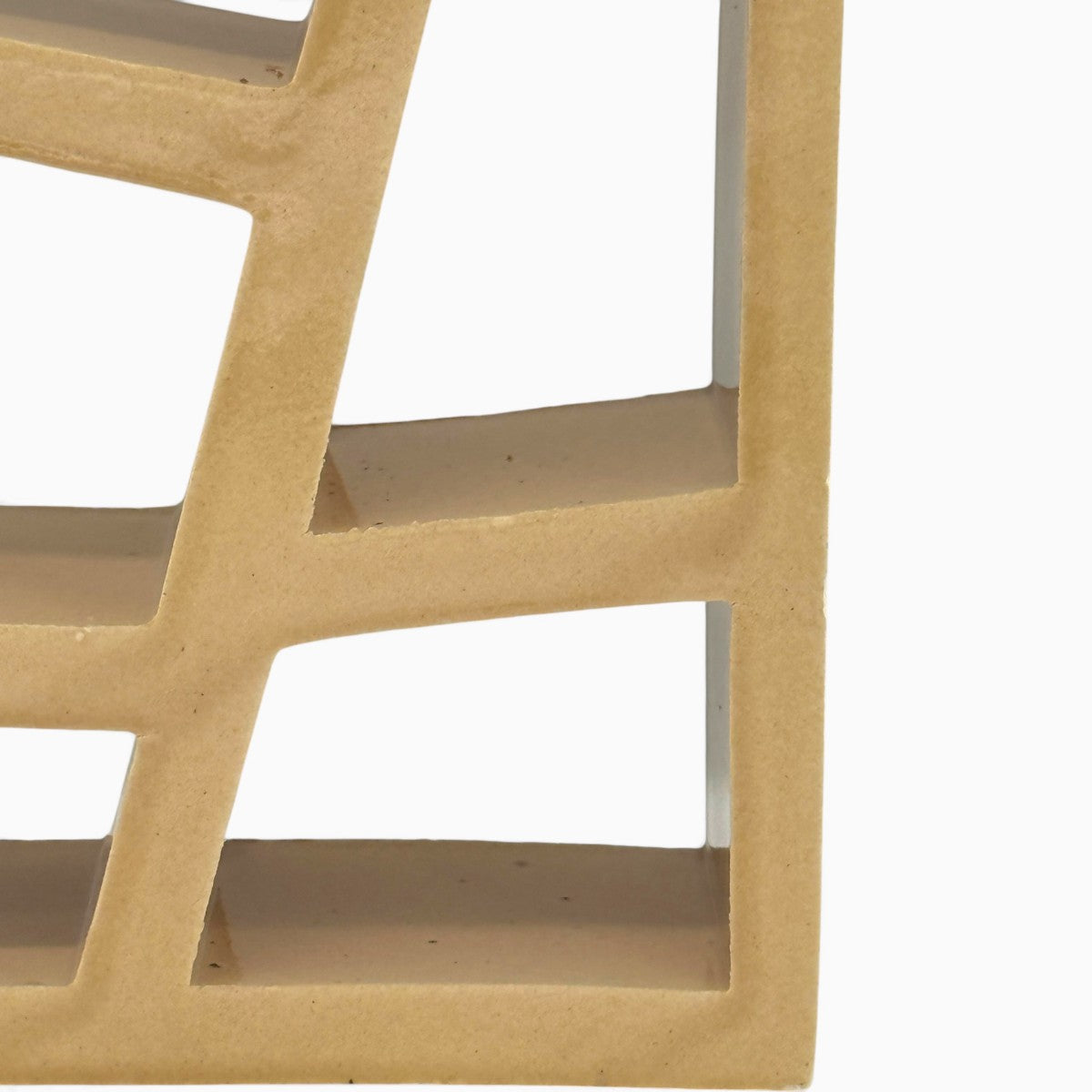 Vista tre quarti della scultura geometrica Matrice Ocra in ceramica smaltata giallo ocra